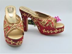 Our new collection of wedding shoes which we offer for you. These feature zardozi hand embroidered design on raw silk fabric. They are a red with beautiful design imbedded with gold rhinestones and gold zari work in the shape of leaves along with zari and gold rhinestones border on platform base. They feature a round toe chunky heel design. They have a heel design measuring 5 inches from bottom of heel to top of heel and platform base in front of 1 inch. They are comfortable to wear all day. The Designer Red Heels For Wedding, Gold Open Toe Block Heels For Wedding, Festive Embellished Open Toe Heels, Formal Open Toe Heels For Festive Occasions, Formal Festive Open Toe Heels, Traditional Open Toe Heels For Party, Festive Open Toe Wedding Shoes, Festive Gold High Heels, Traditional High Heel Festive Heels