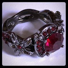 a close up of a ring with red stones