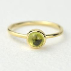 A stunning green peridot stacking ring made from solid 9ct yellow gold. Choose to wear the ring on its own, or mix and match it with other stacking rings from the Nebula collection, or why not add a sparkling Andromeda diamond ring?Peridot is a beautiful juicy green gemstone and the birthstone of August. It is one of only a few stones to come in only one colour, a lovely olive green and is said to bring a wonderful year to whoever wears it. It's warm glowing colour is a reminder of summer and of Gold Stackable Rings With Peridot Birthstone, Dainty Green Peridot Rings, Green Peridot Stackable Rings, Yellow Gold Stackable Rings With Peridot, Peridot Gemstone Stackable Rings, Yellow Gold Peridot Stackable Rings For Anniversary, Green Peridot Stackable Promise Rings, Stackable Yellow Gold Peridot Jewelry, Stackable Peridot Gemstone Rings