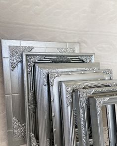 four silver frames sitting next to each other on a wall