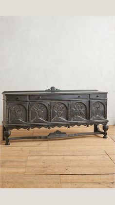 an ornately carved wooden chest is on the floor