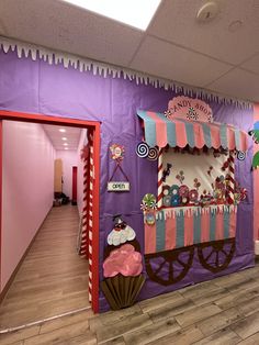 an office decorated in pink, purple and green with cupcakes on the cart