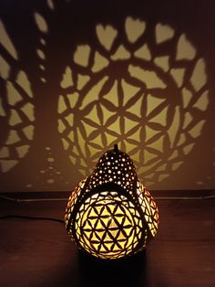 a lamp that is sitting on a table with shadows cast on the wall behind it