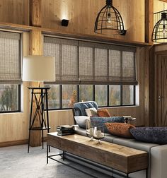 a living room filled with furniture and lots of windows covered in shades on the walls