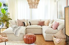 a living room with a large sectional couch and lots of pillows on top of it