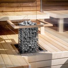 an outdoor hot tub with rocks in the middle and wood flooring around it,