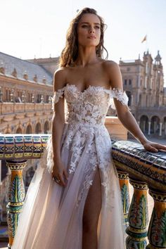 a woman in a wedding dress leaning on a railing