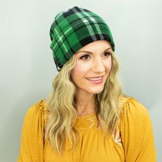 a woman with blonde hair wearing a green and black plaid beanie on her head