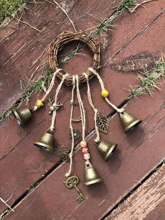 several bells hanging from a rope on top of a wooden floor next to some grass