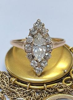 an antique diamond ring sits on top of a gold plate with chain links around it