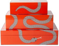 three boxes with designs on them are stacked in the shape of two snakes, one is orange and the other is white