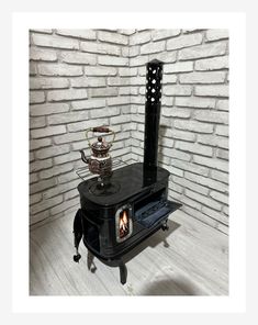 an old fashioned stove sitting in front of a brick wall