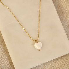 Handmade 18k Gold Plated necklace with heart Freshwater shell pendant. (This necklace is made with natural materials, therefore colour & size may vary) Chain length = 18 inches. LINK TO MATCHING EARRINGS: https://www.etsy.com/uk/listing/1343668452/shell-heart-huggie-earrings-in-18k-gold?click_key=1315d4aac0c008cb6a1a0f4148985f10f6f96f50%3A1343668452&click_sum=b04c2e5a&ref=shop_home_active_1&frs=1 Designed & Handmade in the UK Gold Plated. Base metal is Brass. DELIVERY & PACKAGING: All our Earrings come beautifully presented in a hand printed drawstring pouch. All our earrings come with a thank you note. You can add a gift message free of charge at checkout. All our packaging is plastic free!  All orders are sent via Royal Mail & dispatched within 1-3 working days. CARE: We recommend to kee White Heart Pendant Necklace With Delicate Chain, White Heart Pendant Necklace As Gift For Her, Dainty White Heart Pendant Necklace, Dainty White Heart-shaped Necklace, White Heart-shaped Necklace As A Gift For Her, White Heart Shaped Necklace For Her, Minimalist White Necklace For Valentine's Day, White Heart Beads Charm Necklace With Heart Pendant, White Heart Pendant Charm Necklace With Heart Beads