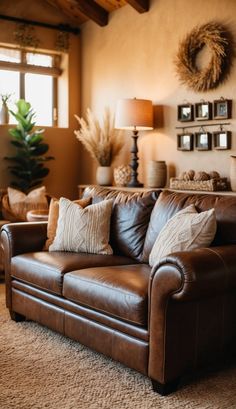 a brown leather couch sitting in a living room next to a window