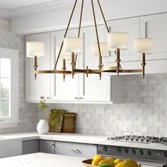 a kitchen with white cabinets and marble counter tops