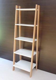 a wooden shelf with three shelves on each side, against a brown wall and white floor