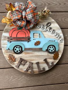 a wooden sign that says welcome fall and a blue truck with a pumpkin on it