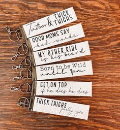 four pairs of scissors with handwritten labels on them sitting on a wooden table next to each other