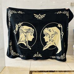 two women's heads are depicted on the back of a black and gold blanket