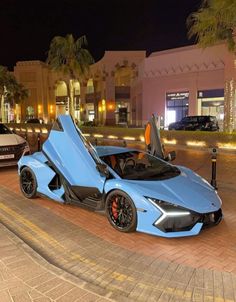 a blue sports car parked in front of a building