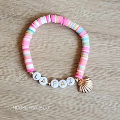 Embrace the coastal vibes with our Shell-Kissed Pink Beach Bracelet. This pink-themed beauty is adorned with golden shell charms, evoking memories of sandy shores and ocean breezes. Our bracelets are available in a variety of sizes up to 8". These custom bracelets are made with premium materials and a high attention to detail.  This listing offers a personalized bracelet experience, allowing you to customize the location detail to make it uniquely yours. HOW TO ORDER: --------------------------- Pink Strand Bracelets For Beach Season, Pink Strand Bracelets For Beach Style, Pink Beachy Bracelets For Beach Season, Bohemian Pink Jewelry For Beach Party, Pink Strand Bracelet For Vacation, Personalized Pink Friendship Bracelets For Beach, Handmade Pink Jewelry For Beach Party, Pink Jewelry For Beach Season Vacation, Pink Jewelry For Beach Party