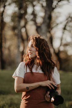 a woman with long hair holding a camera