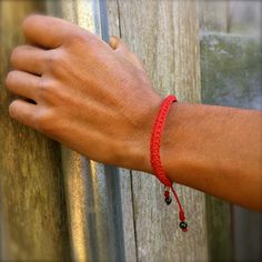 "RED CORD BRACELET: This hand-knotted, unisex, woven bracelet includes two genuine Hematite stones and a Rumi Sumaq logo bead. In a striking shade of red, the bracelet makes a wonderful \"love bracelet.\" Purchase two as friendship bracelets. Or as a unique \"his and her\" couples bracelet set. Custom made in all wrist sizes, this red macrame bracelet could also be a great parent-child bracelet set. SUPERIOR CRAFTSMANSHIP: Please don't confuse this woven bracelet with your typical, imported fibe Handmade Red Casual Friendship Bracelets, Casual Red Handmade Friendship Bracelets, Casual Red Braided Bracelet, Adjustable Red Hand Wrapped Friendship Bracelets, Red Hand-strung Braided Friendship Bracelets, Hand-strung Red Braided Friendship Bracelets, Red Macrame Beaded Bracelets For Friendship, Casual Red Braided Bracelets As Gift, Casual Red Braided Bracelets For Gift