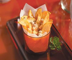 a glass filled with french fries sitting on top of a tray