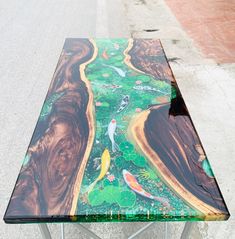 a glass table with fish in the water on it's sides and green grass