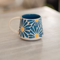 a blue and white coffee cup sitting on top of a table