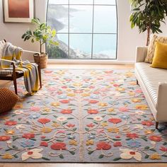 a living room with a couch, chair and rug on the floor in front of a window