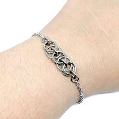 "This bracelet is made with a section of the Helm chain chainmaille weave, done in super shiny stainless steel jump rings. Helm is an incredibly versatile chainmaille weave and is one of my most popular styles. It looks great alone as it is, paired with other bracelets for a stacked looked, or even with with charms attached! Also can make a great anklet! You can find all my Helm weave items here: https://www.etsy.com/shop/ZenJumpsChainmaille?search_query=helm Specifications ●Weave: Helm ●Materia Chainmaille Jewelry Patterns, Chain Maille Patterns, Jump Ring Jewelry, Chainmail Bracelet, Chainmail Jewelry, Chain Maille Jewelry, Popular Styles, Minimalist Bracelet, Chain Anklet