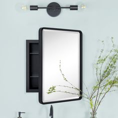 a bathroom with a mirror, sink and vase on the counter top next to it