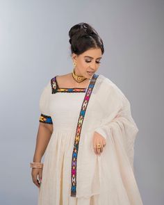 This elegant dress blends tradition with modern flair, making it a standout piece for cultural and formal events. It is adorned with narrow handmade Tilef around the neckline, sleeves and hemline, giving it a sophisticated traditional look. Material Cotton Thread Estimated delivery : 1week to 2weeks Contact WhatsApp +1(304)-306-2784Email: contact@ethiopian.store Embroidery Traditional, Habesha Dress, Ethiopian Dress, Traditional Look, Wedding Dress Chiffon, Dresses Chiffon, Wedding Dresses Simple, Pitcairn Islands, Cotton Thread