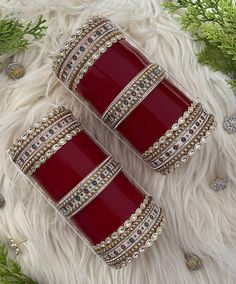 two red and gold cufflinks sitting on top of a white fur covered floor