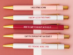 four pens with writing on them sitting next to each other in front of a pink and white background