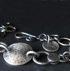 A rustic handmade chain link bracelet handcrafted from sterling silver. Each component has been individually made then oxidized and brushed for an antique appearance.The Details.∞ Artisan handmade∞ Sterling silver∞ Measures 7" long∞ Focal disc measure 5/8"∞ Allow up to 14 business days for fabrication before shipment∞ Gift box included∞ Made in the USA Artisan Silver Hammered Bracelets, Unique Round Bracelets With Oxidized Finish, Rustic Silver Bracelet Jewelry, Artisan Hand Forged Sterling Silver Bracelets, Artisan Sterling Silver Bracelet With Oxidized Finish, Handmade Silver Bohemian Chain Bracelet, Artisan Silver Bracelet With Oxidized Finish, Rustic Round Jewelry With Oxidized Finish, Handmade Vintage Silver Chain Bracelet