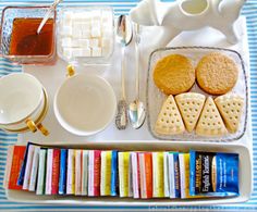 an assortment of cookies, crackers, and other snacks on a tray with spoons