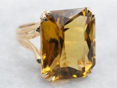 Get ready to make a statement with this ring! Crafted with stunning yellow gold and a sparkling emerald cut citrine stone, this cocktail ring will add a touch of brilliance to any outfit. Perfect for special occasions or just to add some flair to your everyday look. Metal: 10K Yellow Gold Gem: Citrine 15.61 Carats Gem Measurements: 14.3 x 17.7 mm, Emerald Cut Ring Size: 6 Marks: "10K-PS" Stamped on the inside band SKU #: A39967 Each piece has been identified and graded by a Graduate Gemologist who has been certified by the Gemological Institute of America (GIA). We have six brick-and-mortar storefronts in Maine, Massachusetts, and New Hampshire and have been in business for over 25 years! Please visit our Shop's About Page or our website for more information about our jewelry. For question Yellow Citrine Ring, Right Hand Ring, Split Shank Ring, Emerald Cut Rings, Right Hand Rings, Hand Ring, Yellow Citrine, Citrine Ring, Citrine Stone