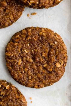 three cookies are sitting on top of a sheet of wax paper and ready to be eaten