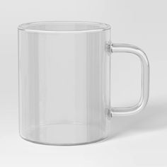 a clear glass mug is shown on a white background with the lid partially closed to reveal an empty cup