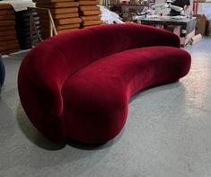 a large red couch sitting on top of a white floor