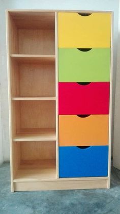 a wooden bookcase with drawers painted in different colors