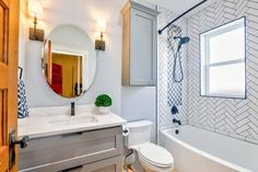 a bathroom with a sink, toilet and bathtub next to a mirror on the wall