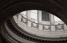 looking up at the ceiling and windows in an old building with stone pillars, arches and columns