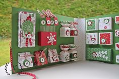 an open christmas card with red and green decorations on it, sitting on top of a table