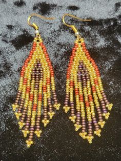 Gold, red, and brown glass seed bead earrings. Beautiful for any occasion. Brown Earrings With Colorful Beads For Gift, Gold Bohemian Beaded Earrings With Faceted Beads, Brown Gold Beads Jewelry For Party, Traditional Gold Beaded Earrings With Colorful Beads, Traditional Gold Earrings With Faceted Beads, Brown Dangle Beaded Earrings With Tiny Beads, Traditional Brown Beaded Earrings With Tiny Beads, Brown Dangling Beads Jewelry For Party, Traditional Brown Beaded Fringe Earrings