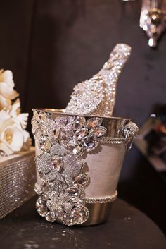 a champagne bottle sitting on top of a table next to a vase with flowers in it