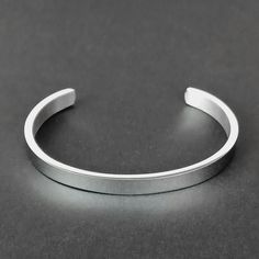 Embrace the Viking tradition of adornment with our Men's Silver Cuff Bracelet, a classic yet modern representation of Norse metalwork. Crafted from high-quality stainless steel, this bangle reflects the Viking passion for decoration in every aspect of life. Its sleek polished finish offers a contemporary twist to traditional Viking aesthetics, making it a perfect accessory for those who value both history and modern style. - Material: Stainless Steel - Rust, scratch and tarnish resistant; hypoal Minimalist Bangle With Stainless Steel Clasp, Adjustable Stainless Steel Bangle With Polished Finish, Adjustable Metal Cuff Bracelet With Polished Finish, Classic Metal Cuff Bracelet, Classic Metal Cuff Bracelets, Classic Stainless Steel Wristband Bracelet, Adjustable Stainless Steel Cuff Bracelet For Formal Occasions, Minimalist Stainless Steel Jewelry With Brushed Finish, Modern Silver Metal Wristband