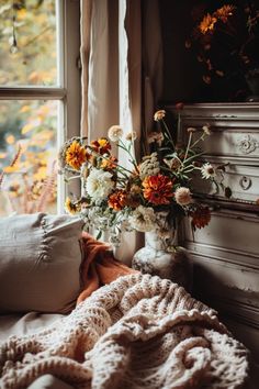 A beautifully decorated living room showing cozy autumn decor with plush blankets, warm colors, and seasonal accents. This pin highlights engaging autumn home decor ideas perfect for creating a warm atmosphere.